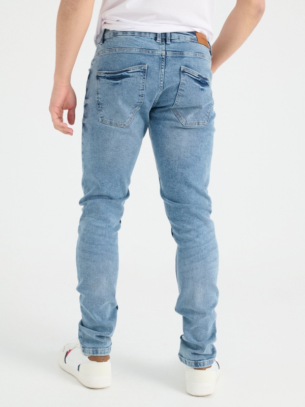 Ripped blue slim jeans blue middle back view