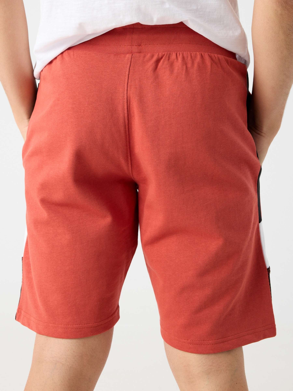 Combined bermuda jogger short with text orangish red detail view