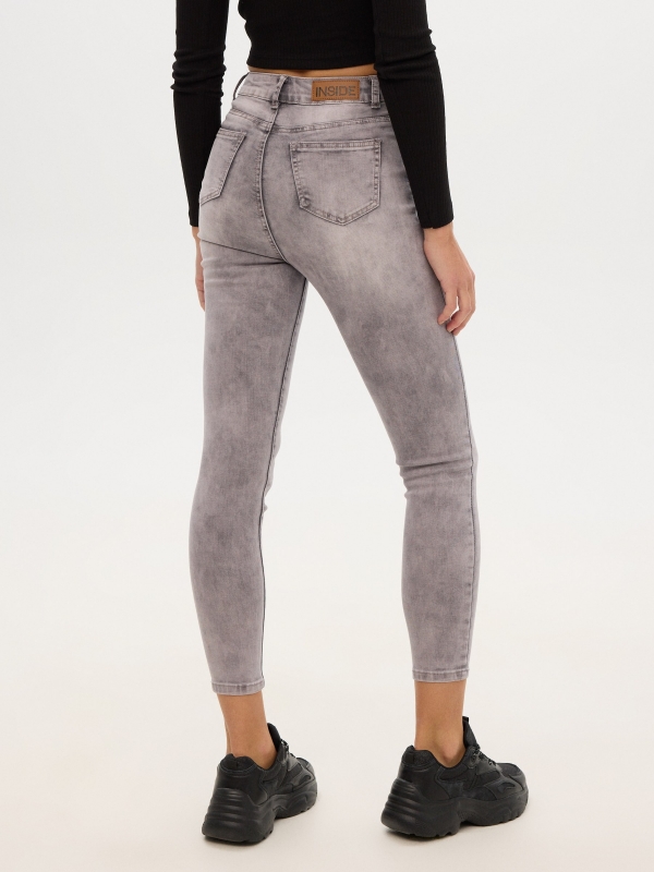 Worn high rise skinny jeans light grey middle back view