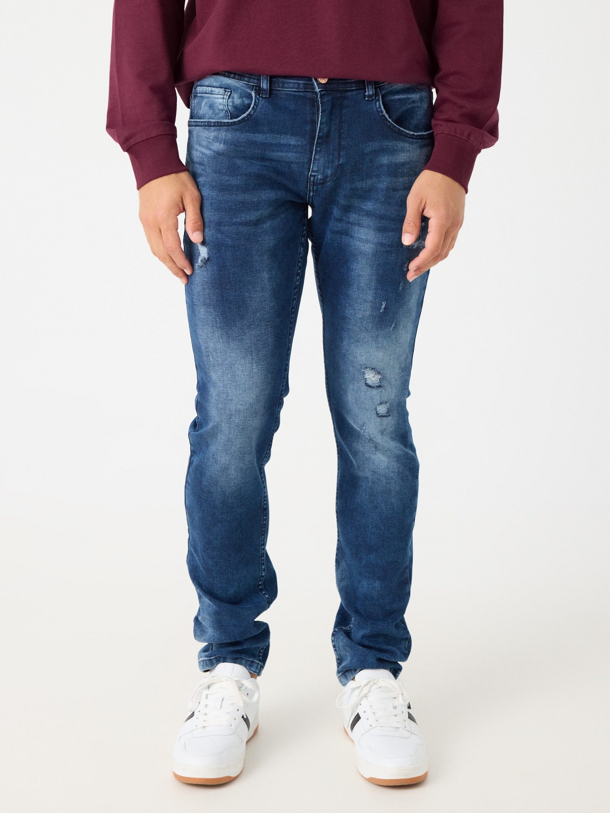 Jeans slim desgastado com rasgos azul marinho vista meia frontal