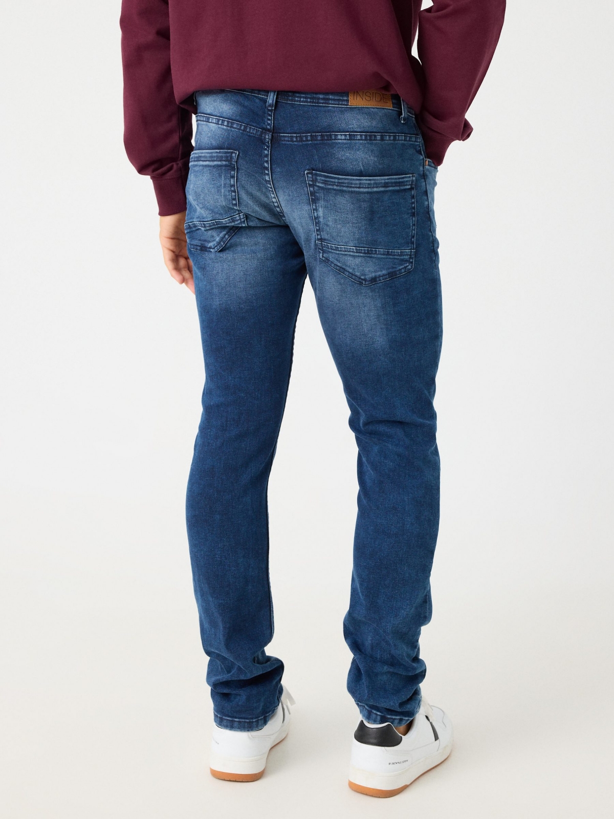 Jeans slim desgastado com rasgos azul marinho vista meia traseira
