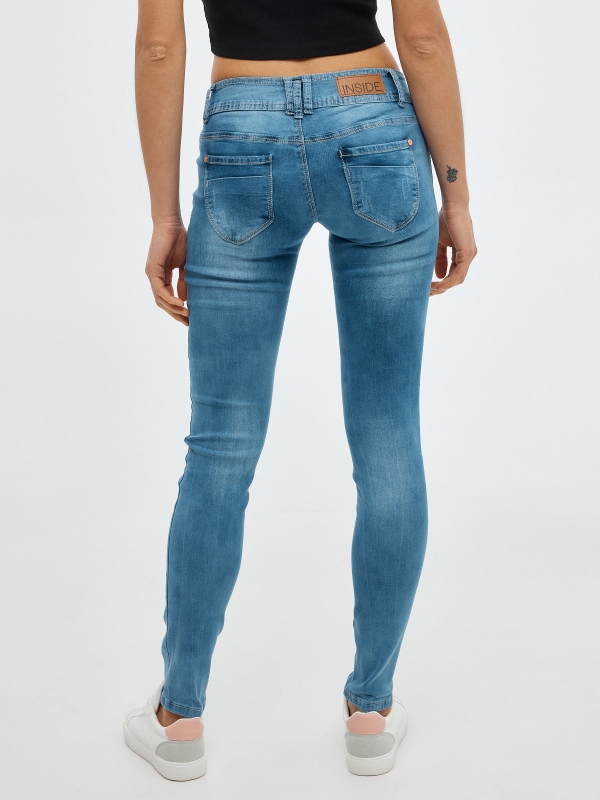 Jeans skinny cintura baixa e efeito lavado azul vista meia traseira