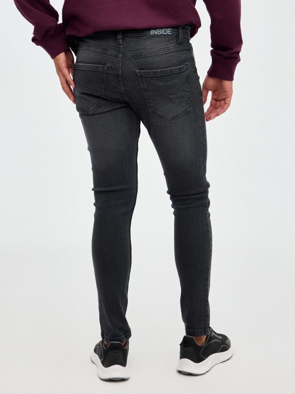 Dark denim skinny jeans black middle back view