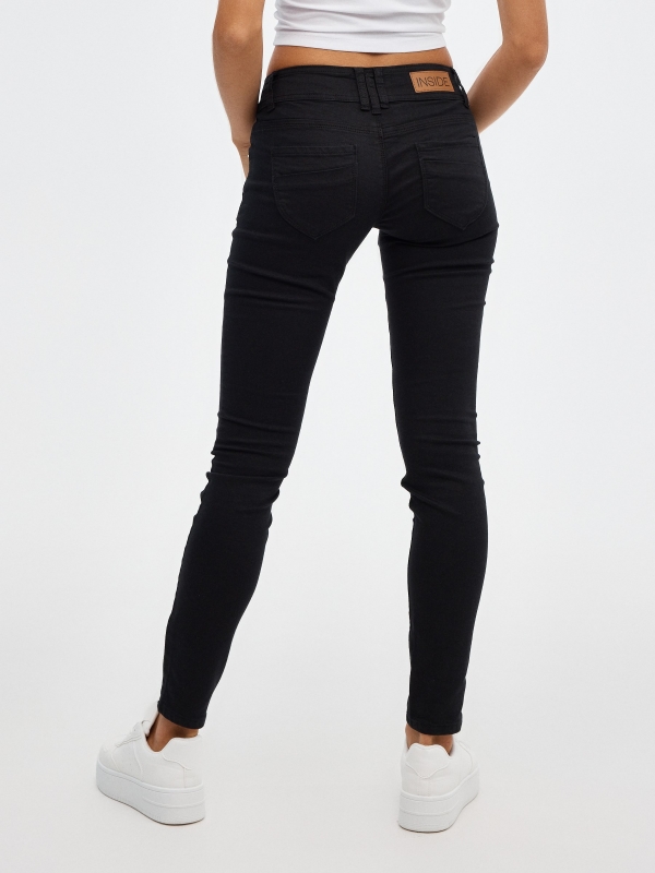 Jeans skinny de tiro bajo negro vista media trasera