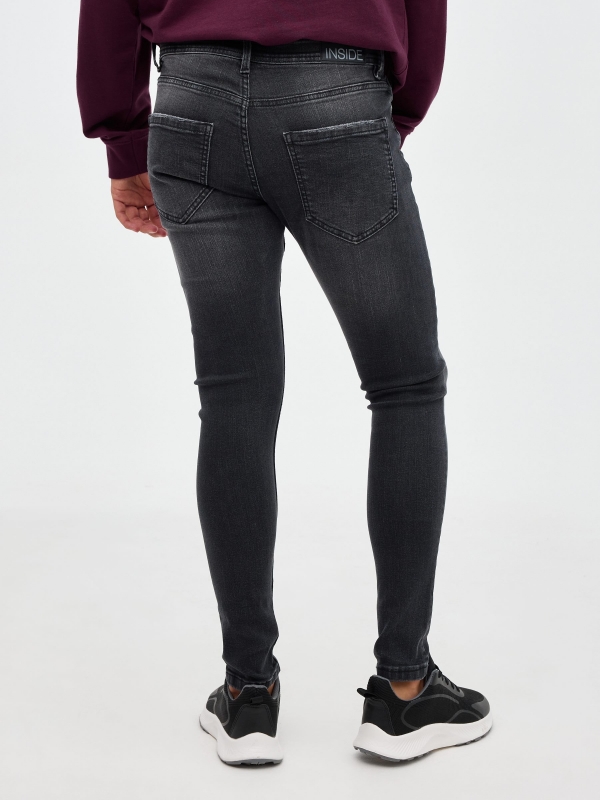 Black super skinny jeans with ripped black middle back view