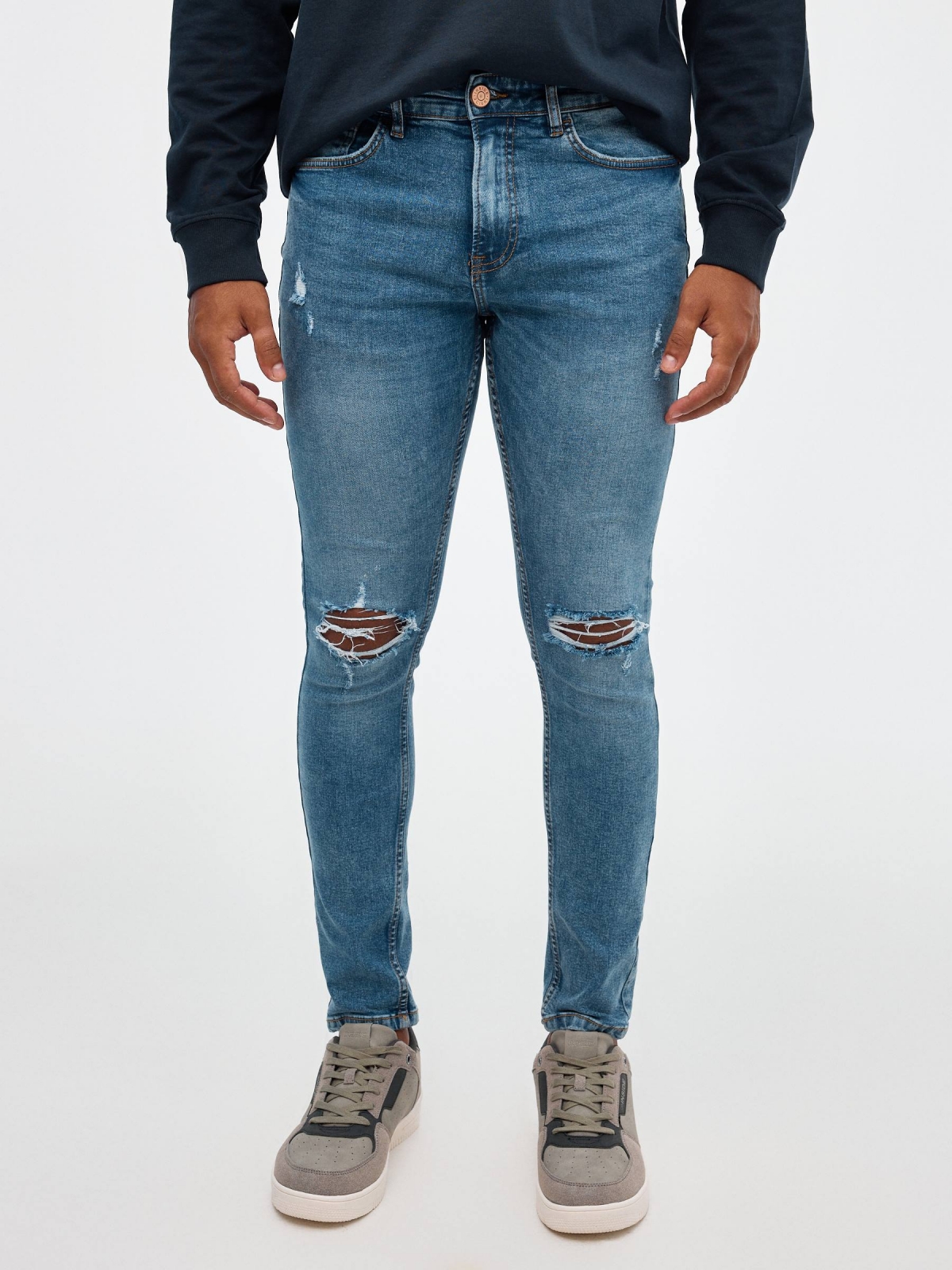 Jeans skinny partes inferiores rasgadas azul vista meia frontal