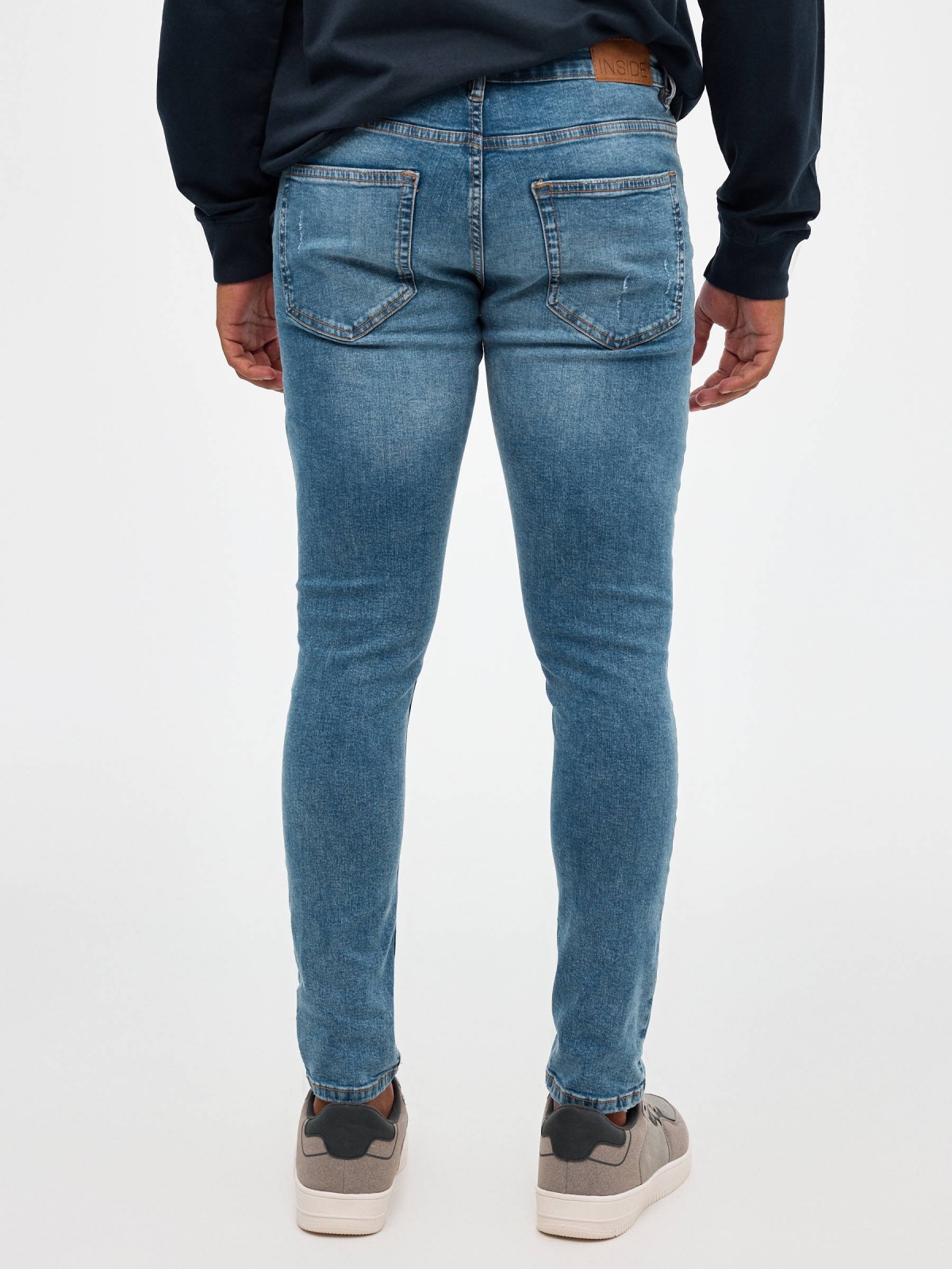 Jeans skinny partes inferiores rasgadas azul vista meia traseira