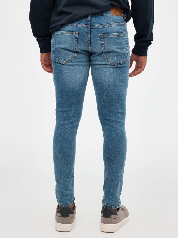 Ripped skinny jeans blue middle back view