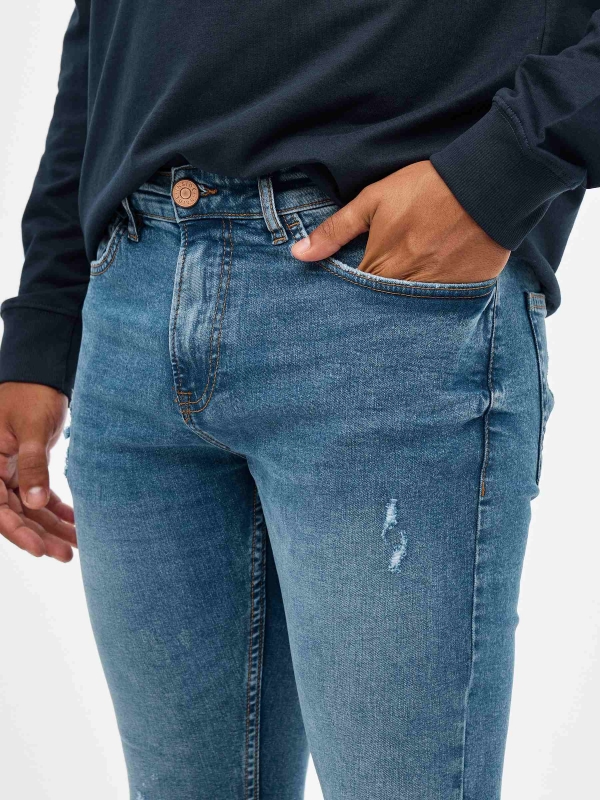 Jeans skinny partes inferiores rasgadas azul vista detalhe