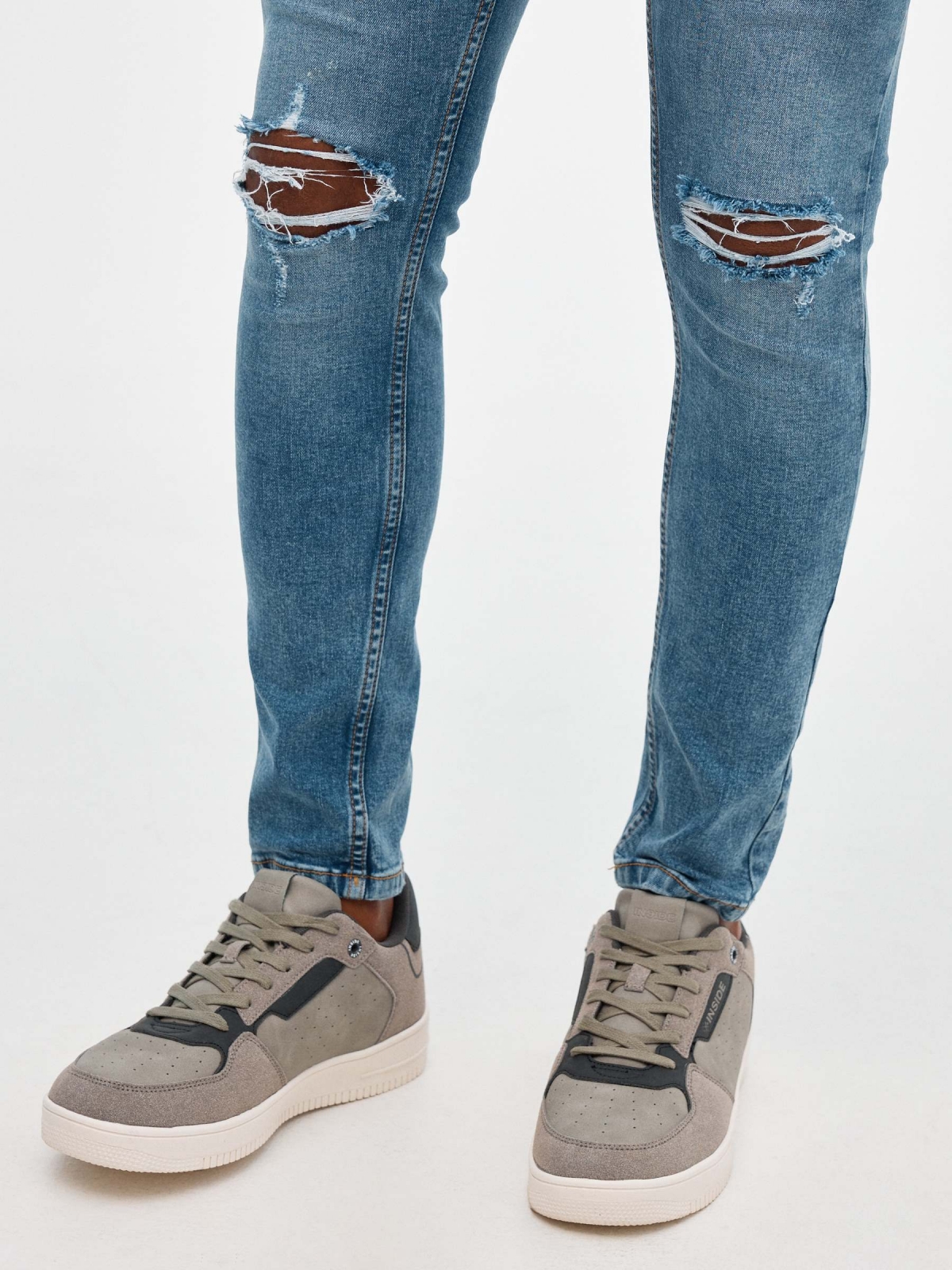 Jeans skinny partes inferiores rasgadas azul vista detalhe