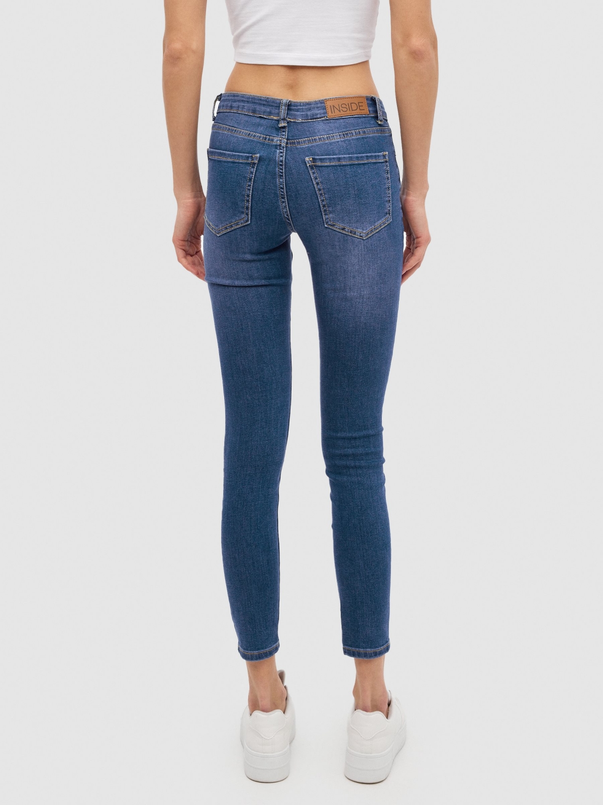 Skinny jeans with mid rise rips blue middle back view