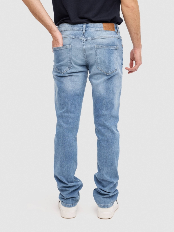 Jeans slim fit azul claro uniforme azul vista meia traseira