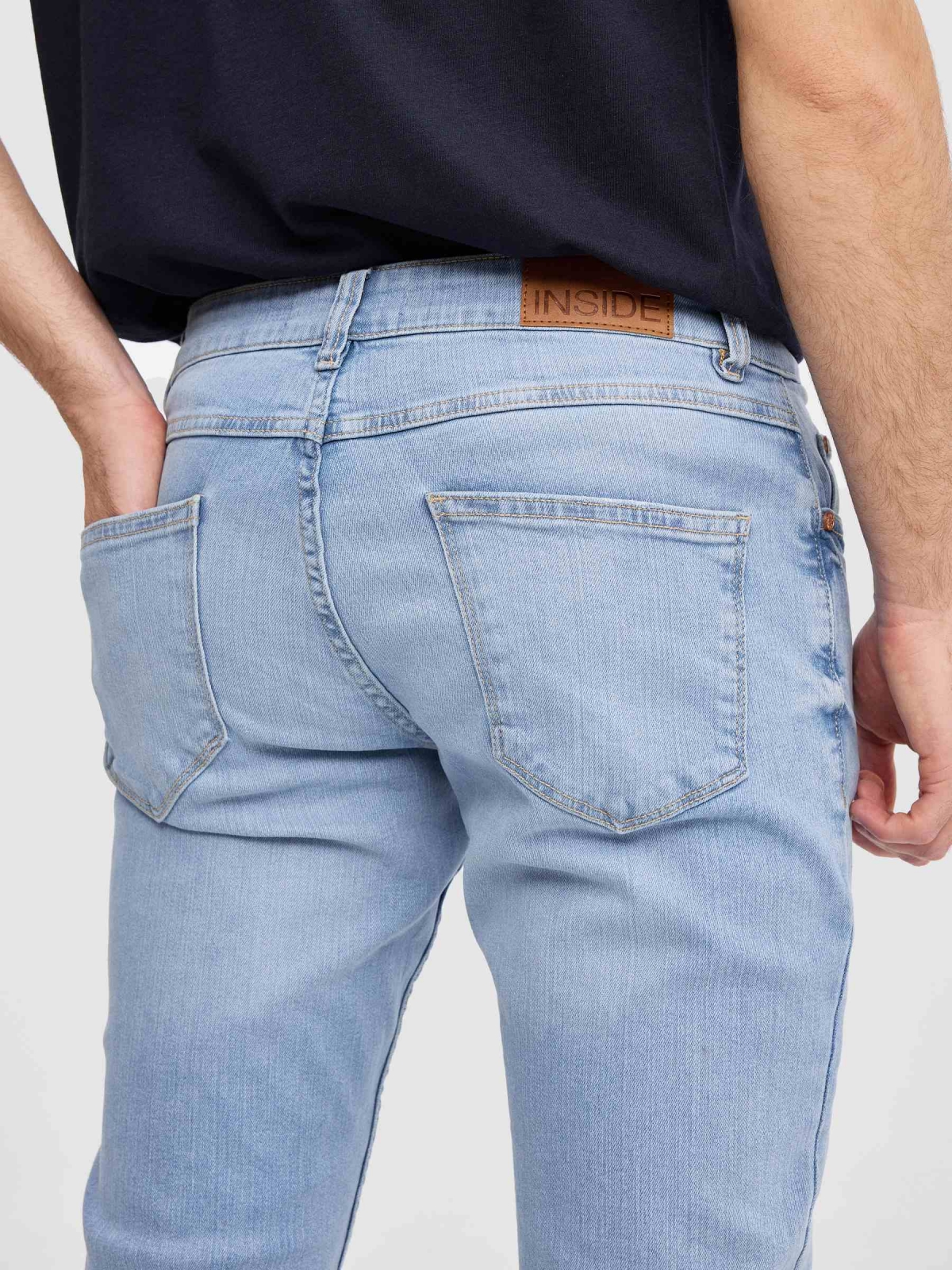 Calça jeans regular fit azul claro lavagem fraca da coxa azul vista detalhe