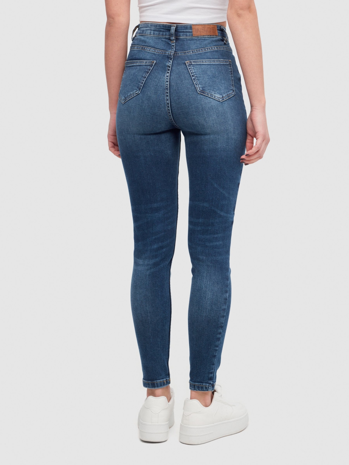 High-waisted skinny jeans with ripped dark blue middle back view