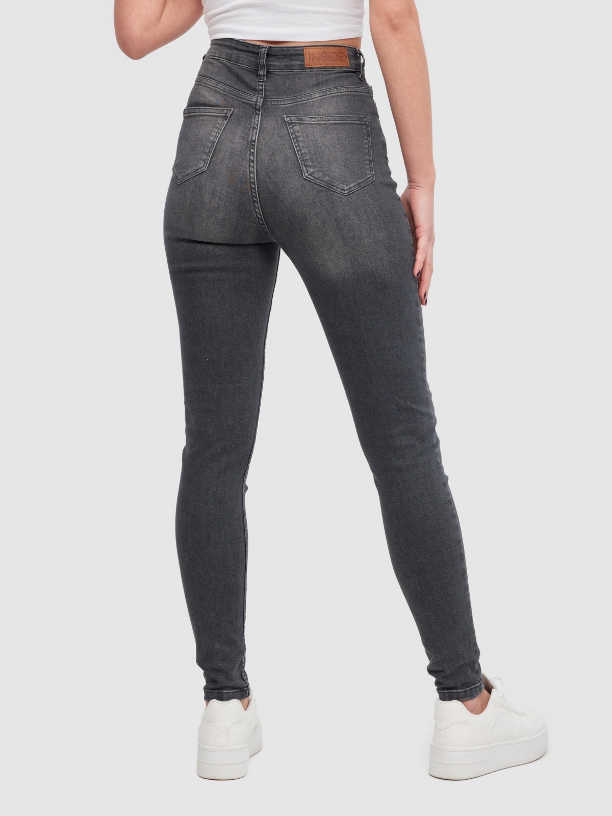 High-waisted skinny jeans with ripped black middle back view