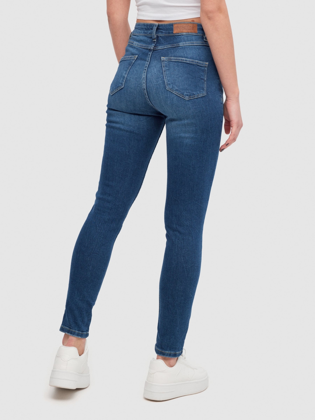 Ripped mid-rise skinny jeans dark blue middle back view