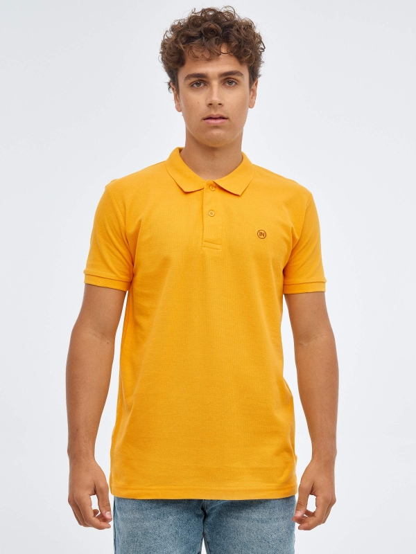 Basic polo shirt with engraved logo ochre middle front view