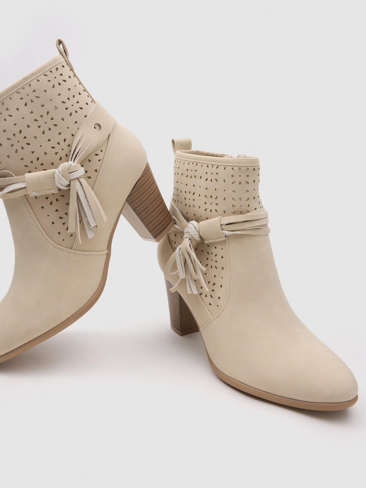 Cream leather-effect medium heel ankle boot with die-cut side bow sand detail view