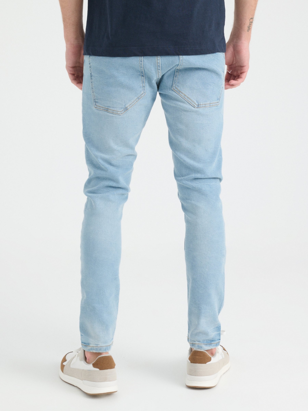 Jeans super slim lavado e rasgado azul claro vista meia traseira