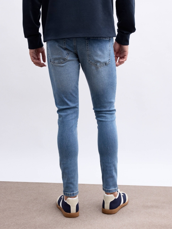 Ripped denim skinny jeans blue middle back view