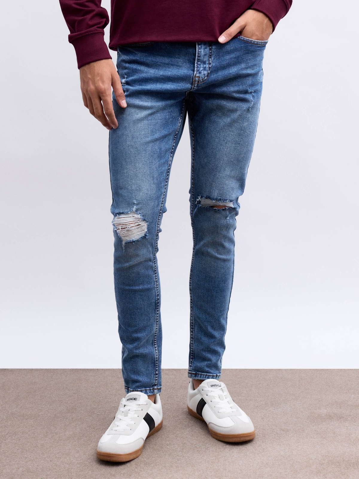 Jeans skinny partes inferiores rasgadas azul vista meia frontal