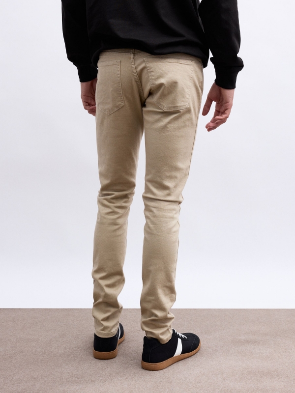 Coloured slim jeans beige middle back view