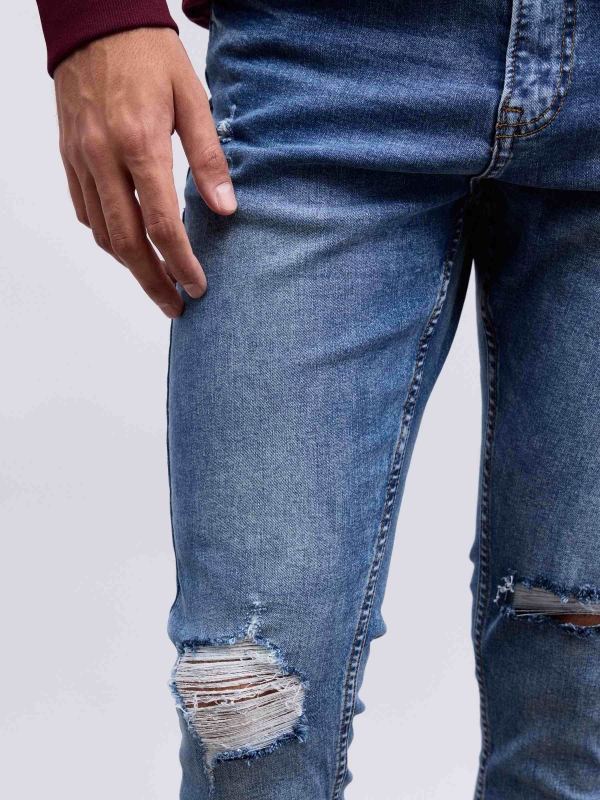 Jeans skinny partes inferiores rasgadas azul vista detalhe