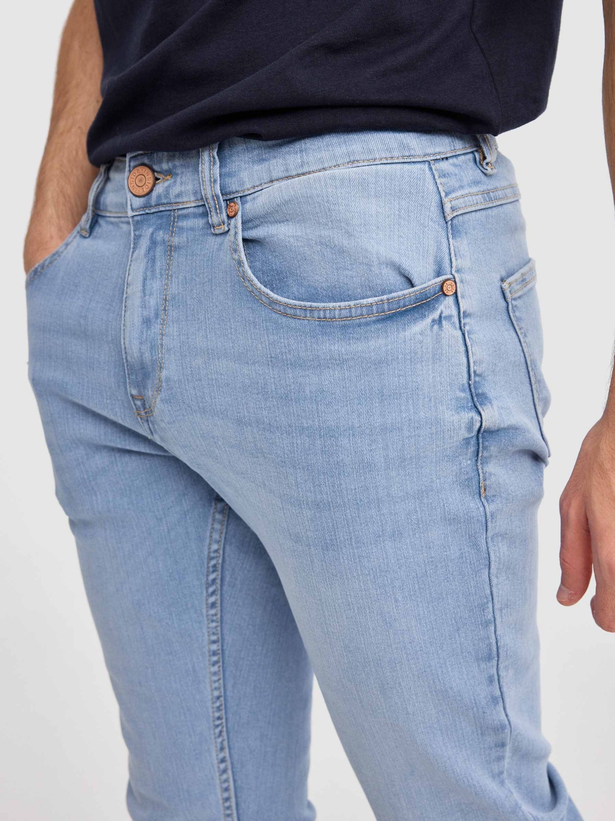 Calça jeans regular fit azul claro lavagem fraca da coxa azul vista detalhe