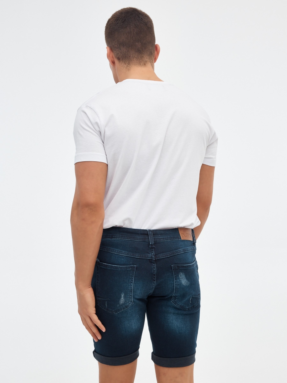 Ripped dark blue denim bermuda short blue middle back view