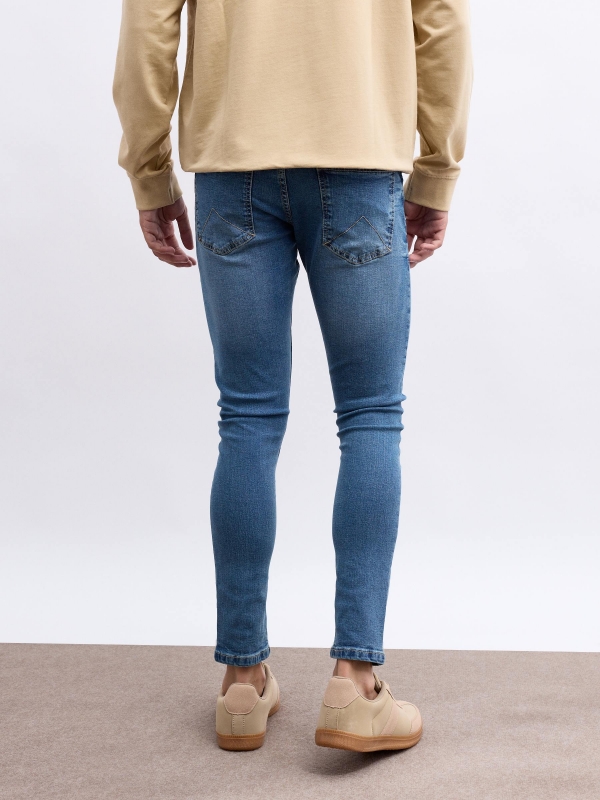 Worn skinny jeans blue middle back view