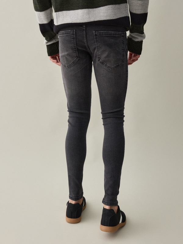 Black super skinny jeans with ripped black middle back view