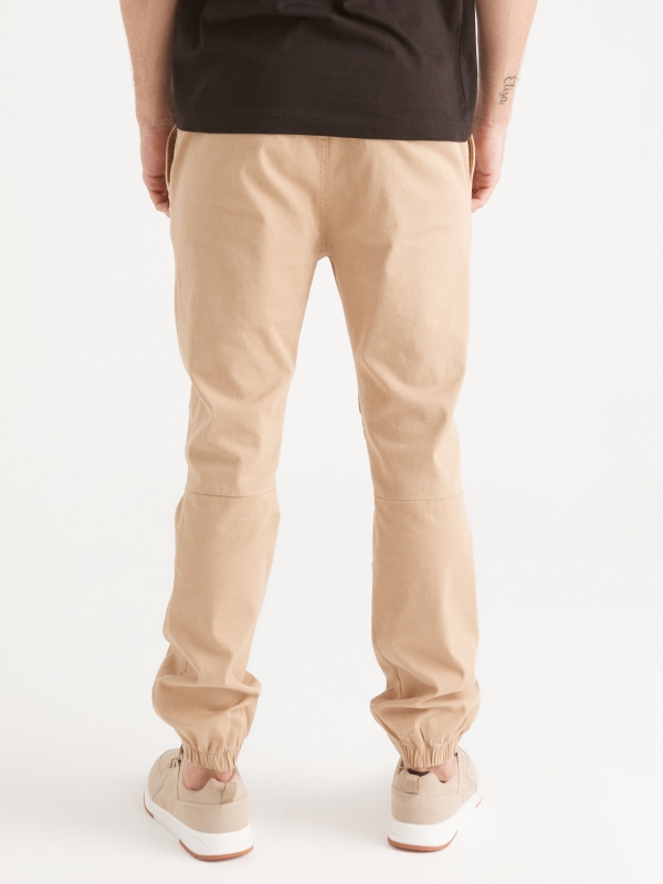 Pantalón jogger costuras beige vista media trasera