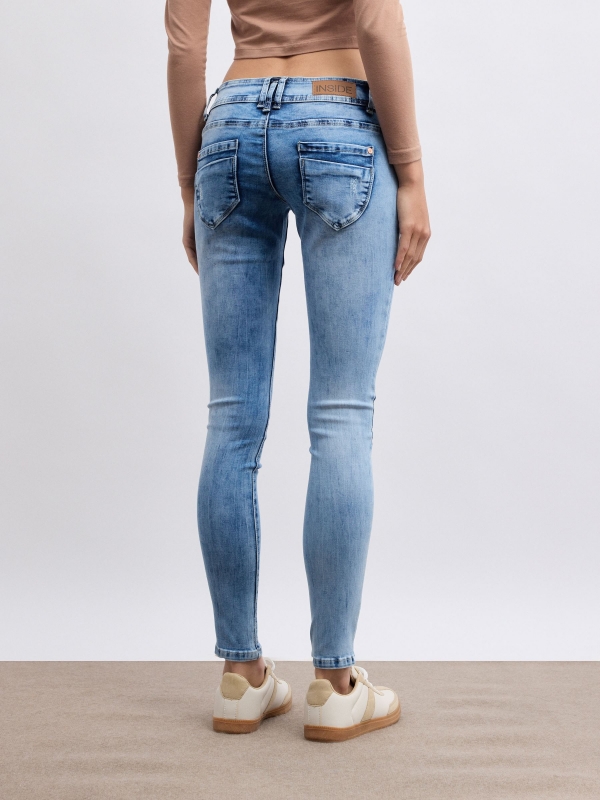 Jeans skinny cintura baixa e efeito lavado azul vista meia traseira