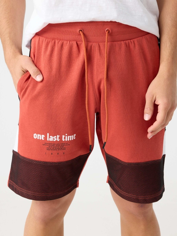 Combined bermuda jogger short with text orangish red detail view