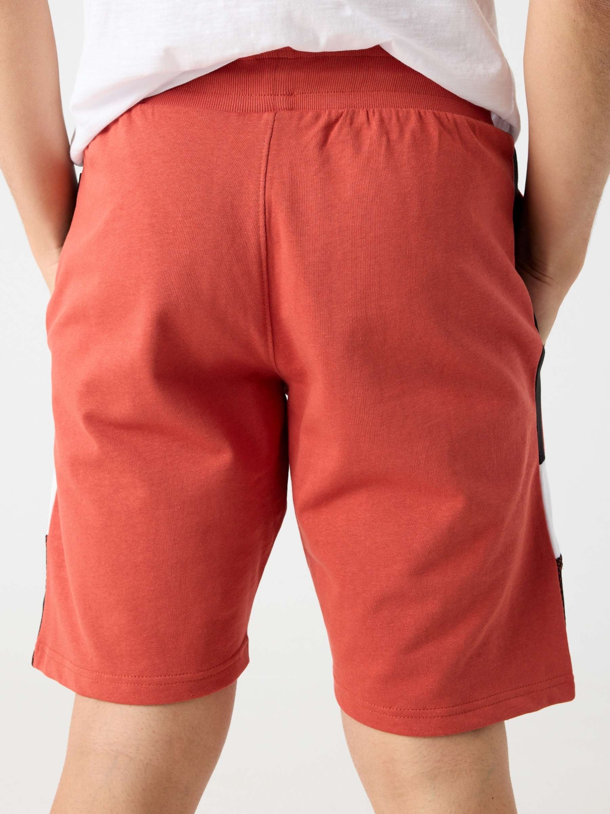 Bermuda jogger combinada com texto vermelho alaranjado vista detalhe