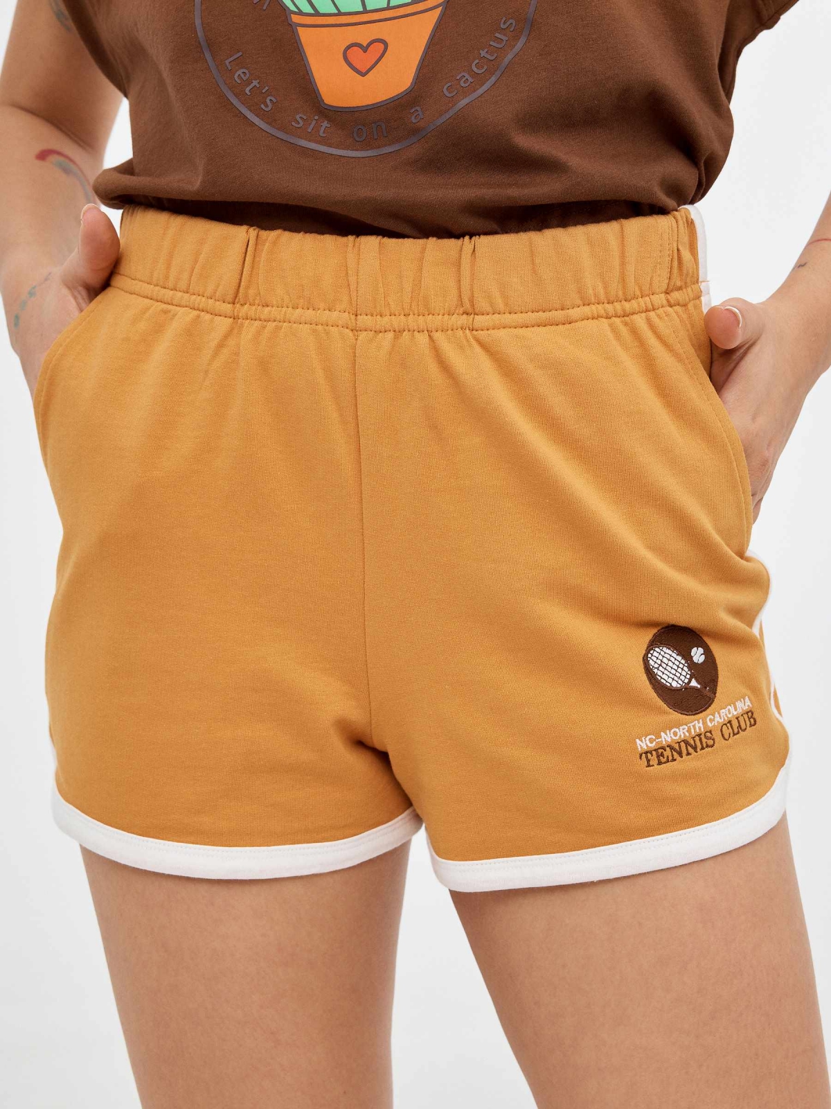 Shorts de punto bordados ocre primer plano