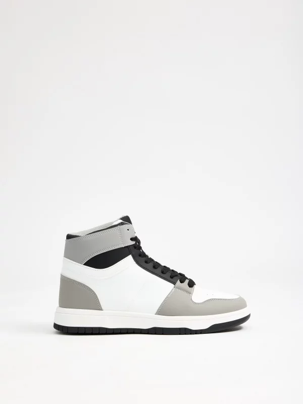 Bota desportiva Trainer preta e branca branco vista perfil