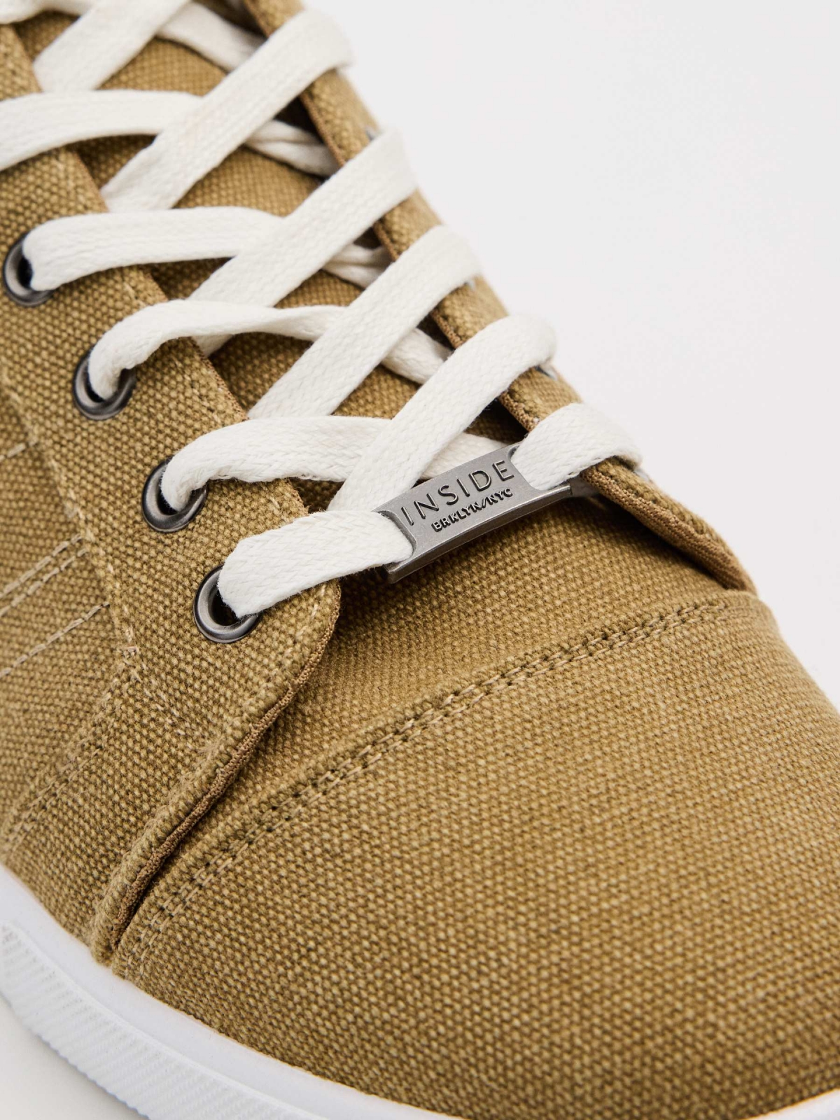 Canvas sneakers sand sand detail view