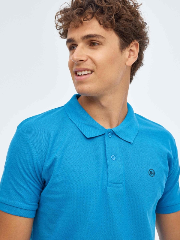 Polo básico logo grabado azul celeste vista detalle