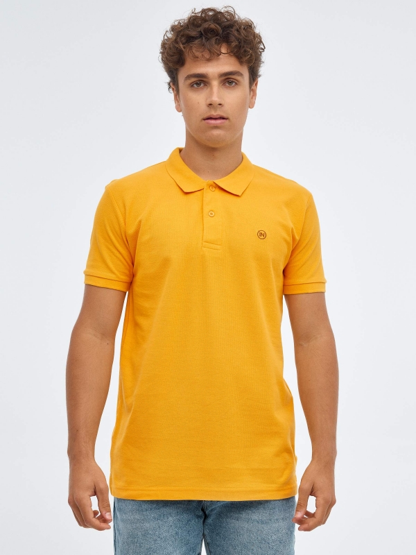 Polo básico logo grabado ocre vista media frontal