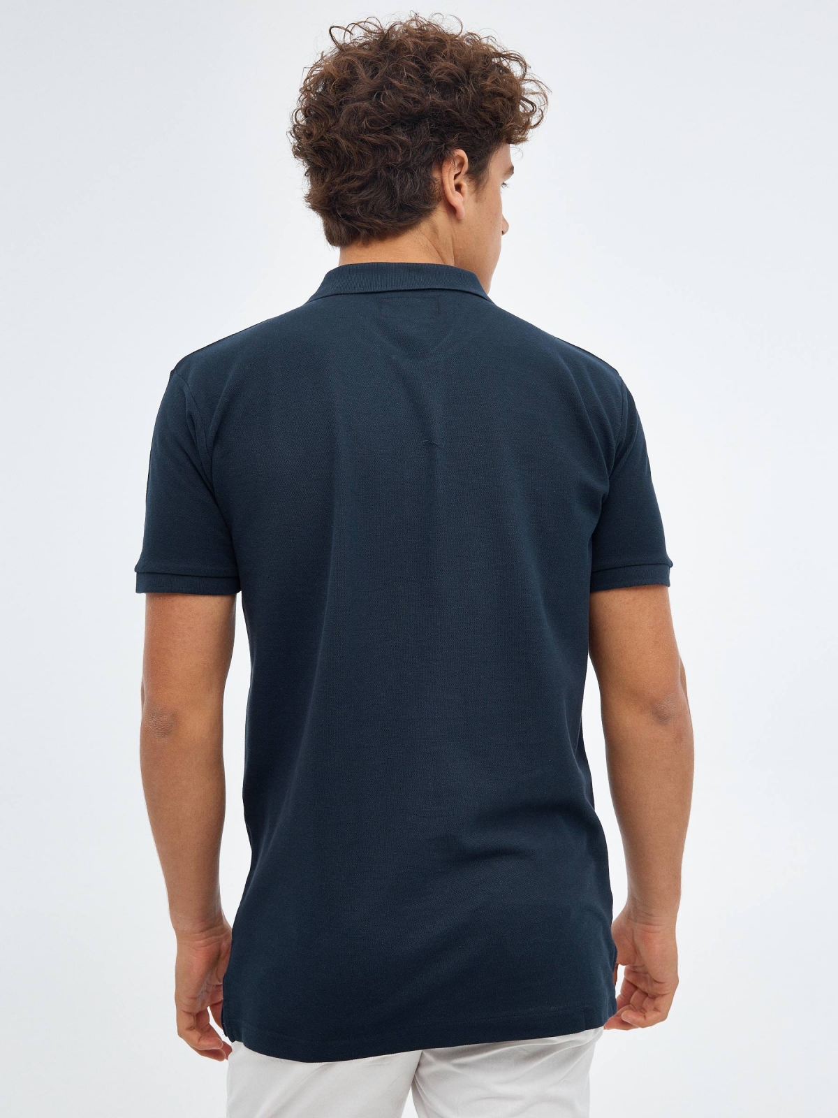 Polo básico logo grabado azul marino vista media trasera