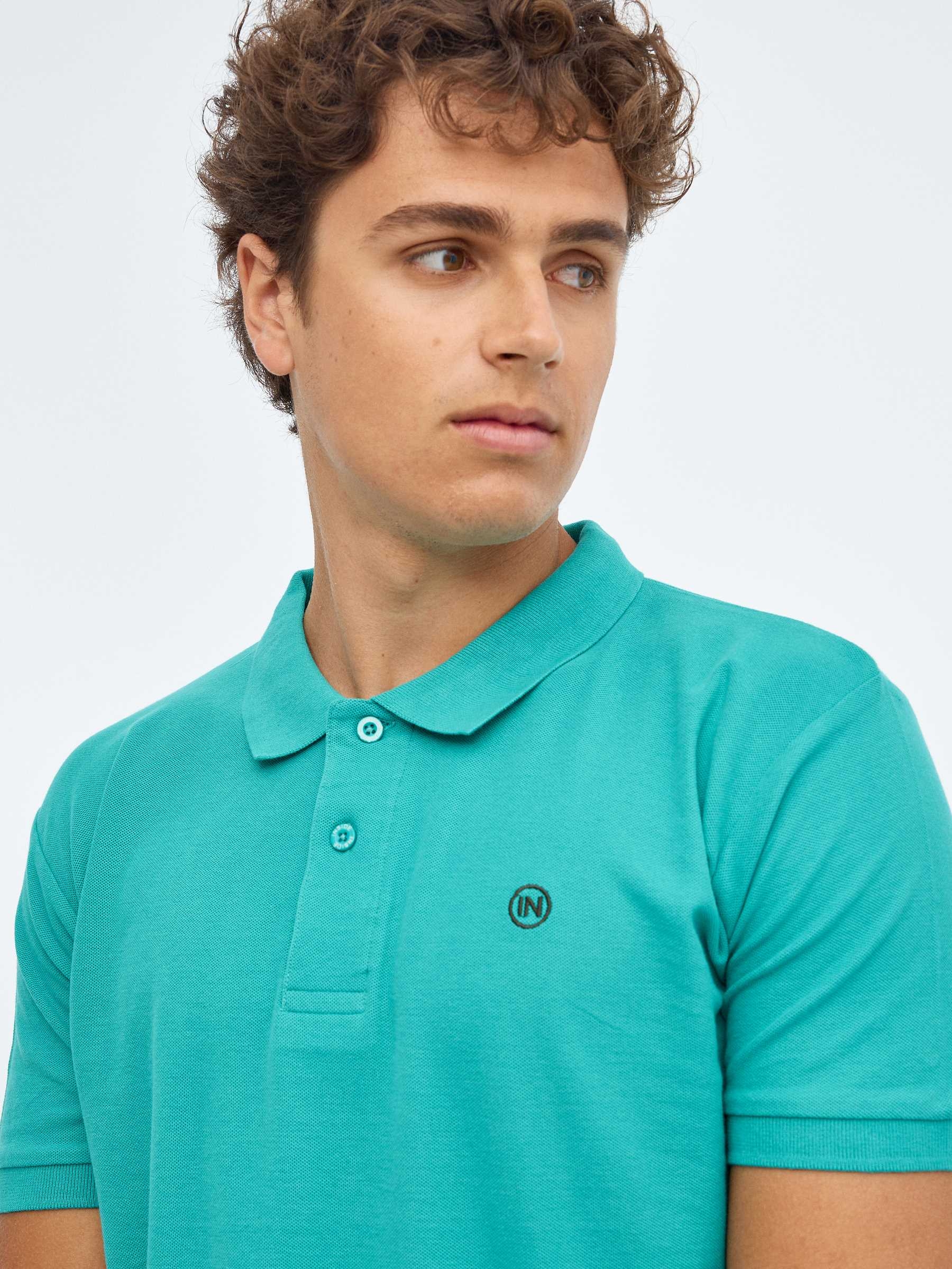 Camisa polo básica com logotipo gravado esmeralda vista meia frontal