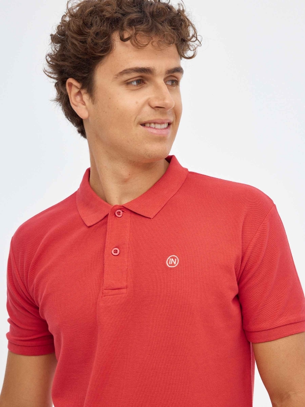 Polo básico logo grabado rojo vista detalle