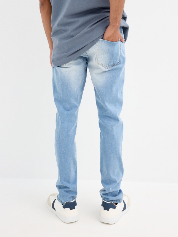 Light blue slim jeans with a worn effect blue middle back view