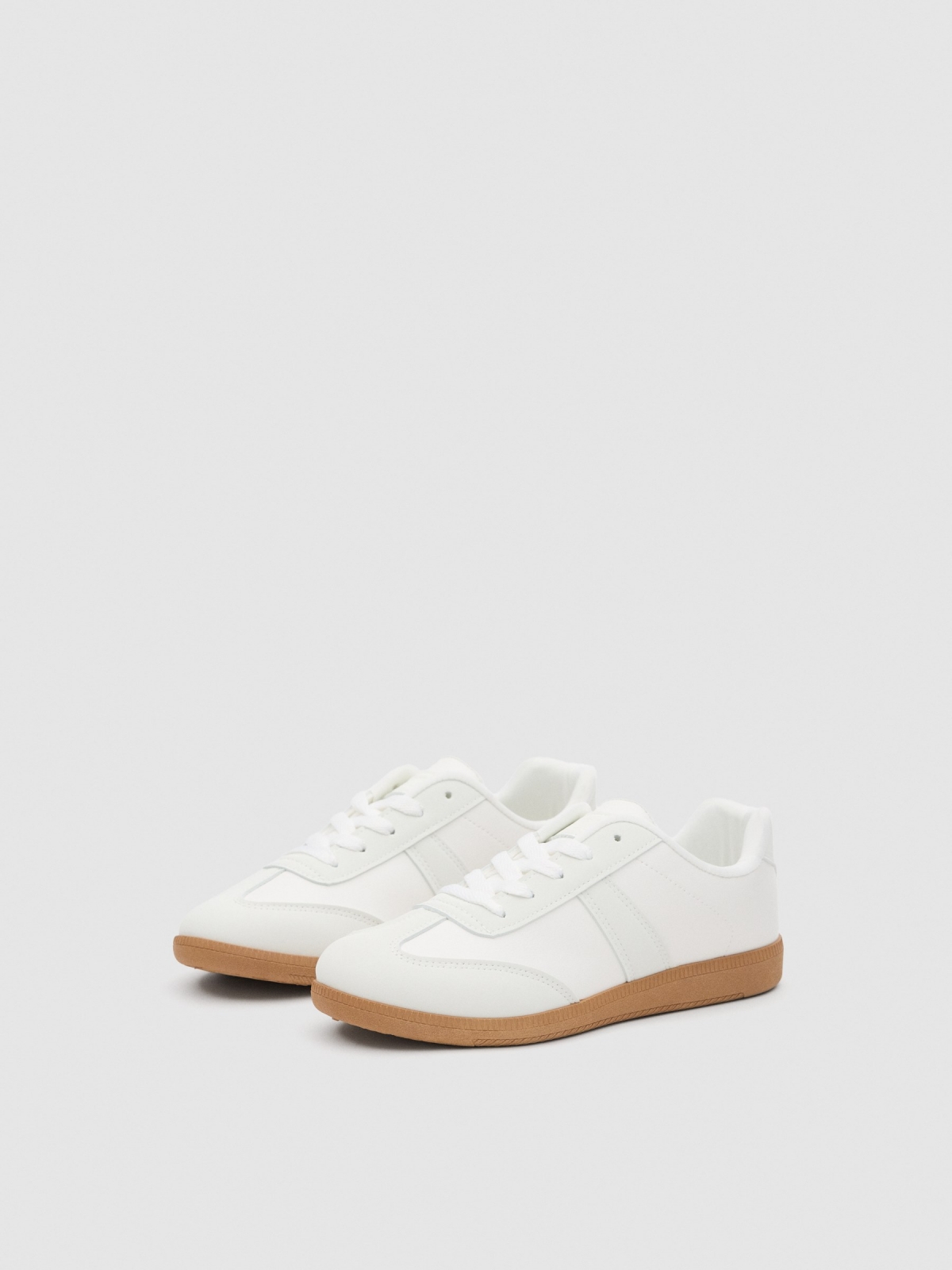 Tênis esportivos brancos branco vista frontal 45º