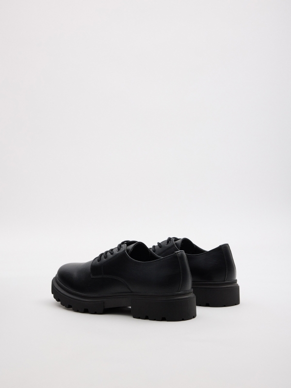 Dress shoe with a serrated sole black 45º back view