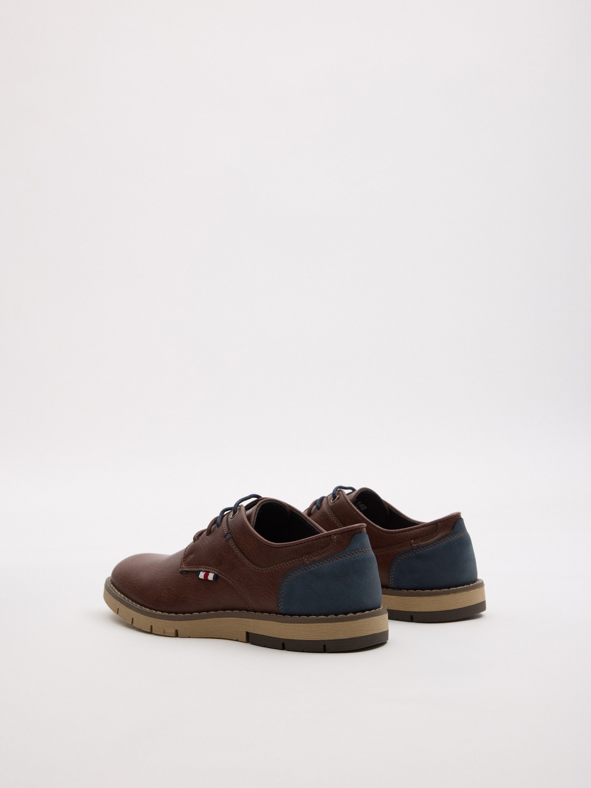 Zapato clásico bicolor marrón oscuro vista trasera 45º