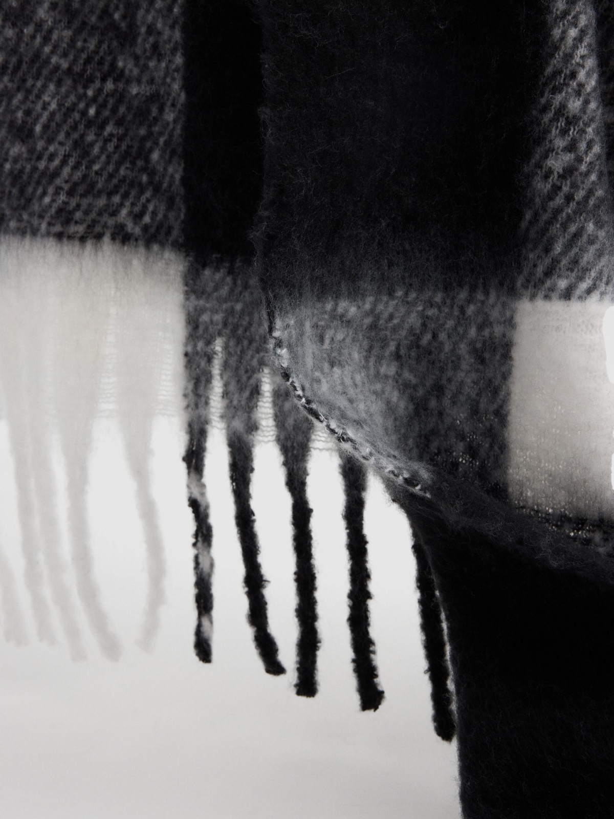 White and black checkered scarf with fringes black with a model