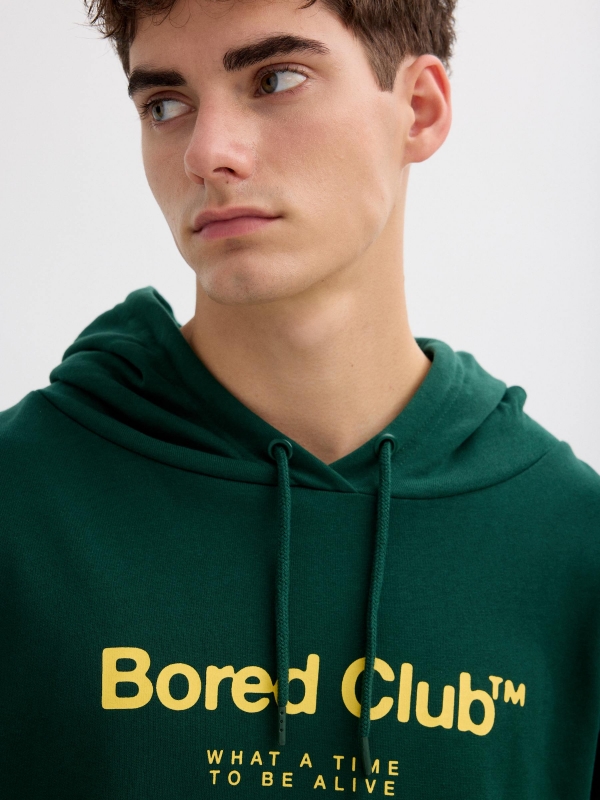 Green hoodie with bored club dark green detail view