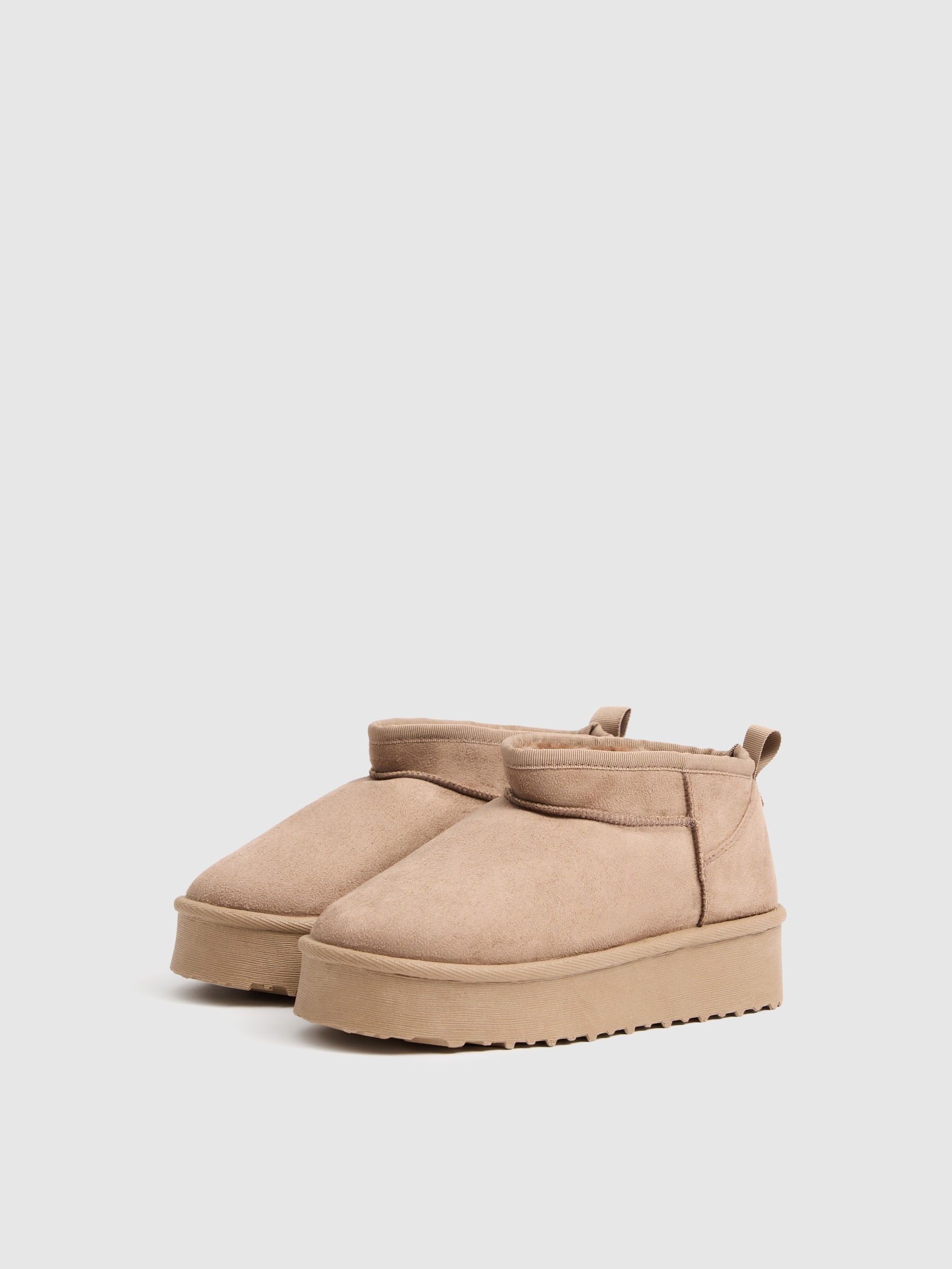 Low ankle boots with brown fur lining sand profile view